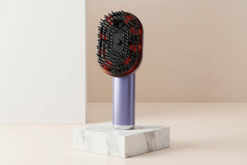 Electric Spray Massage Comb standing upright on luxury stand – Zaloora